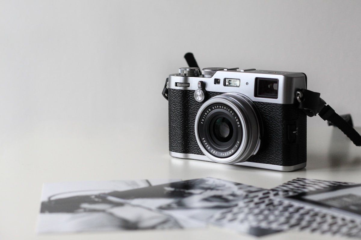 Film camera beside printed photographs